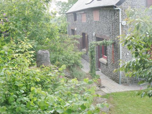 a stone building with a red door and a yard at Gite proche du Val Joly - 4911 - in Willies