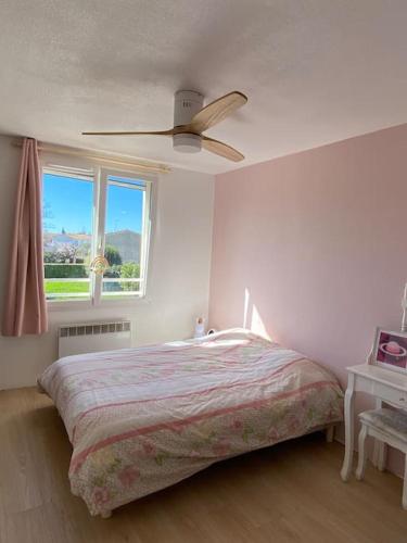 une chambre avec un lit et un ventilateur de plafond dans l'établissement Maison familiale proche plages et Montpellier, à Mauguio
