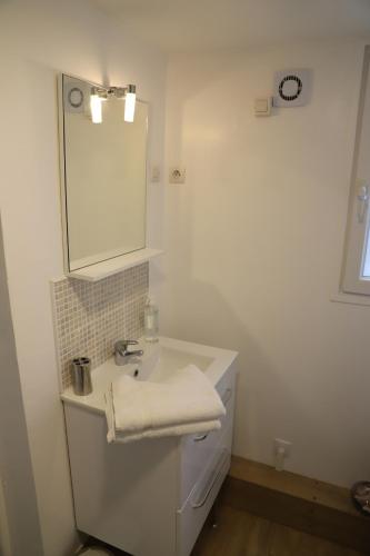 een witte badkamer met een wastafel en een spiegel bij Le Fort Vauban in Ambleteuse
