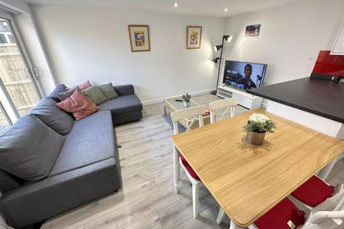 a living room with a couch and a table at Charming New 2BR Detached House-Central Headington- Wi-Fi, Netflix, Top Location in Oxford