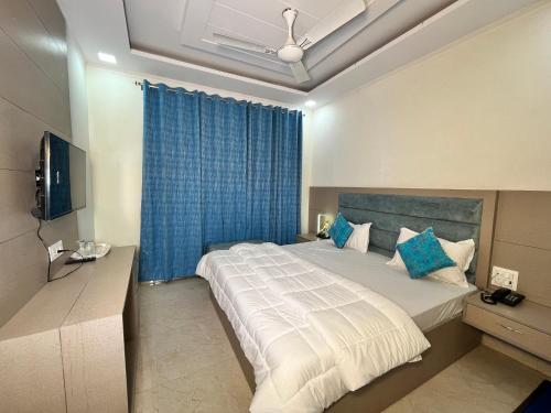 a bedroom with a large bed with a blue curtain at Cosy stay in Haldwāni