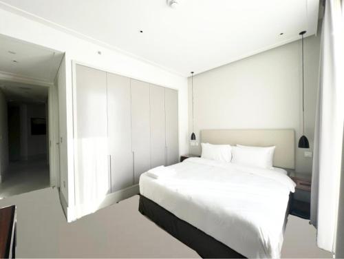 a white bedroom with a large bed and a window at Most City Area Pearl Apartment in Dnipro