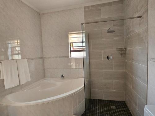 a white bathroom with a tub and a shower at Lanina Self Catering Apartments in Johannesburg