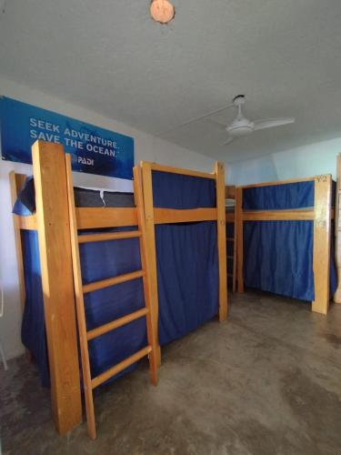 a room with two bunk beds and a sign on the wall at Blue Magic Hostel in Cozumel