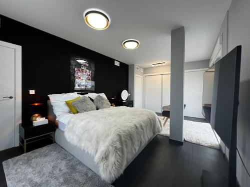 ein Schlafzimmer mit einem großen Bett mit einer schwarzen Wand in der Unterkunft Casa Bella ~ Luxurious Villa in Alicante in Gran Alacant