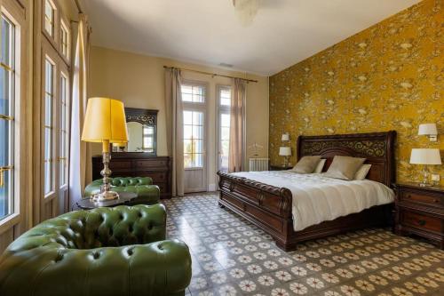 une chambre avec un lit, un canapé et une chaise dans l'établissement Le Marquisat gîte de charme en Minervois, à Olonzac