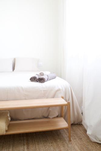 a bedroom with a white bed and a wooden table at Vanilla! 1 Bedroom Apartment in Puerto de la Cruz