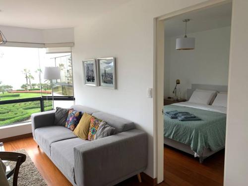 un soggiorno con divano e letto di Apartamento frente al mar a Lima