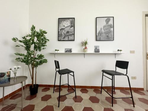 a room with two chairs and a table and a plant at Sant'Oliva28 in Palermo