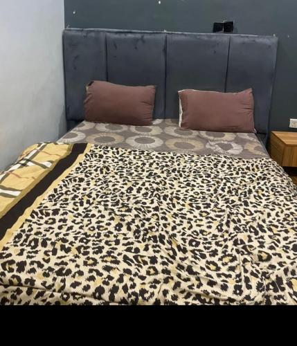 a bed with a leopard print blanket on it at Thilda Hotel and Suites in Alimosho