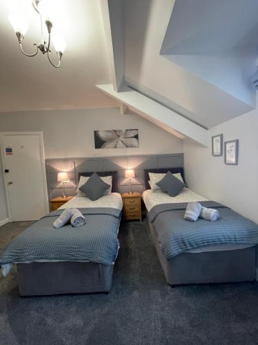 two twin beds in a room with two lamps at Rivendell Guest House in Keswick