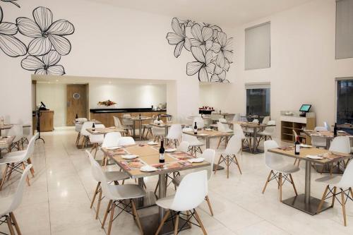 a restaurant with tables and chairs and flowers on the wall at Fiesta Inn Naucalpan in Mexico City