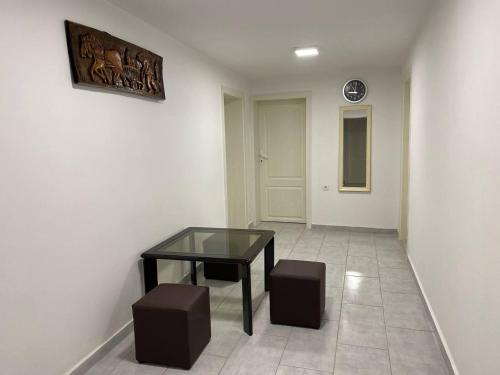 a room with a glass table and two stools at FIA House in Skopje