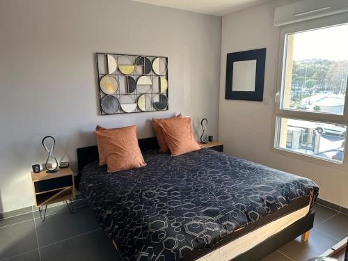 een slaapkamer met een bed en een raam bij Joli appartement résidence neuve in Saint-Mandrier-sur-Mer