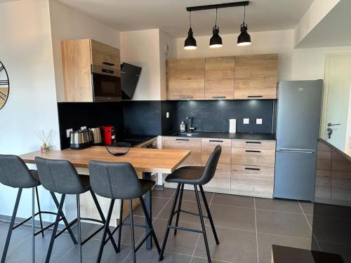 een keuken met een houten tafel en 4 stoelen bij Joli appartement résidence neuve in Saint-Mandrier-sur-Mer