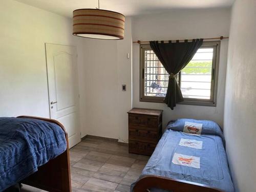 a bedroom with two twin beds and a window at Hostal del Sol - Fisherton in Rosario