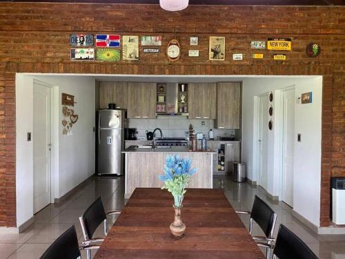 a kitchen with a table with a vase of flowers on it at Hostal del Sol - Fisherton in Rosario