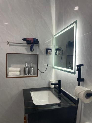 un bagno con lavandino e specchio di Cozy, Comfy Homestay a Hithadhoo