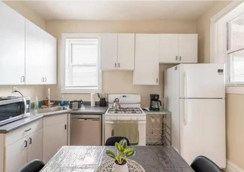 a kitchen with a table and a white refrigerator at The Roscoe Village Guesthouse in Chicago