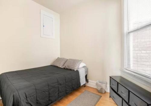 1 dormitorio con 1 cama, vestidor y ventana en The Roscoe Village Guesthouse, en Chicago