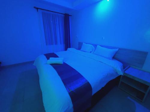 a bedroom with a bed with a blue light at COMFORT E SUITES in Nairobi