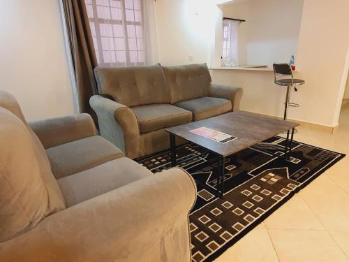a living room with a couch and a coffee table at COMFORT E SUITES in Nairobi