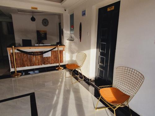 a room with two chairs and a black door at COMFORT E SUITES in Nairobi