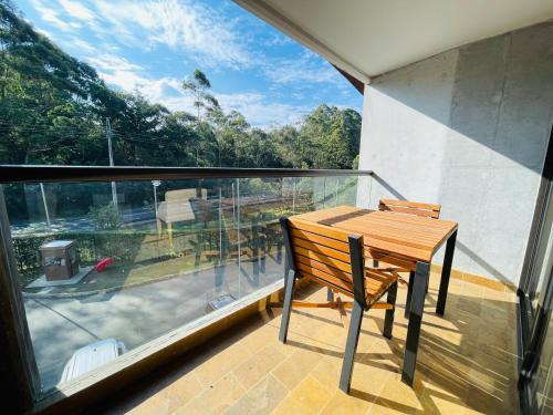 a wooden table and chair on a balcony with a view at Suite hotelera rio verde cerca al aeropuerto in Rionegro
