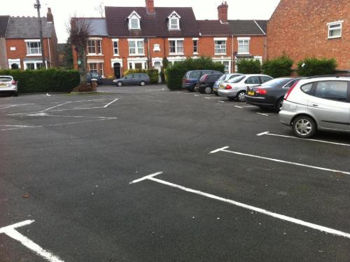 a parking lot with cars parked in it at Grosvenor Hotel Rugby in Rugby