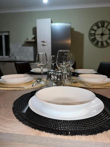 a table with a white plate and wine glasses on it at Susannah's Place in Żejtun