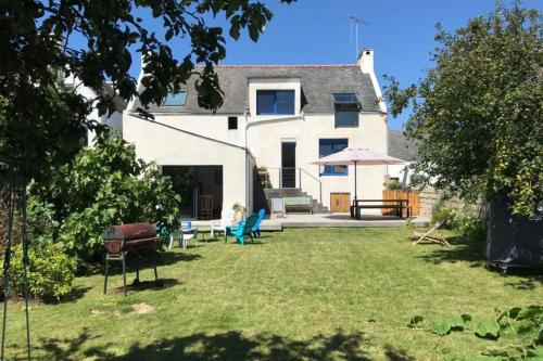 ein Haus mit einem Garten mit Stühlen und einem Grill in der Unterkunft Spacieuse maison - Petite mer in Riantec