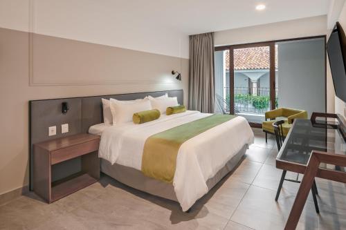 a hotel room with a bed and a balcony at Gamma Orizaba Grand Hotel de France in Orizaba
