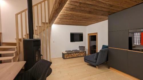 a living room with a staircase and a fireplace at Walliser Stadel in Fieschertal