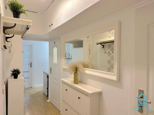 a white kitchen with a sink and a mirror at Danzig Room in Gdańsk