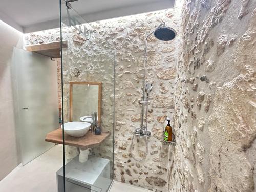 a bathroom with a glass shower with a sink at Barbara Studios in Rethymno