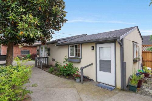 a small house with a white door in a yard at Spacious Retreat with guest house, game room, parking in N Tacoma in Tacoma