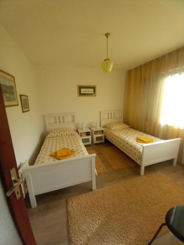 a bedroom with two beds and a window at Kuća za odmor VB-IDRO in Tuhelj