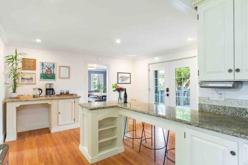 a kitchen with white cabinets and a large counter top at Spacious Retreat with guest house, game room, parking in N Tacoma in Tacoma