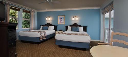 2 camas en una habitación con paredes azules en Disney's Key West Resort Studio room sleeps 4, en Orlando