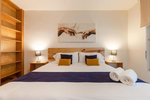 a bedroom with a large white bed with two lamps at Via Tendenza Condos in Playa del Carmen