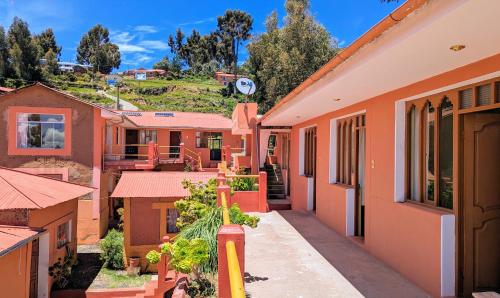 una fila de casas en una ciudad con una colina en el fondo en Amantani sol Andino en Ocosuyo