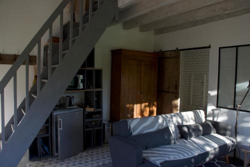 a living room with a blue couch and a staircase at Maison Saint Georges in Saint-Georges-sur-Cher