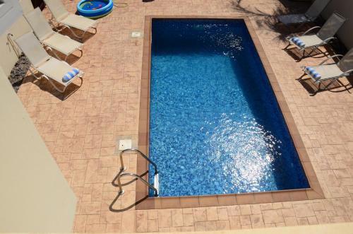 an overhead view of a swimming pool with chairs at Villa millie Cyprus in Protaras