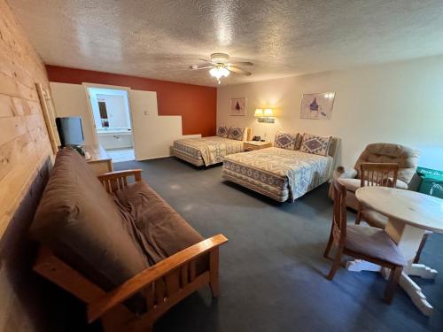 uma sala de estar com um sofá, uma cama e uma mesa em Vista Del Rio Lodge em Chama