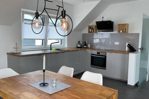 uma cozinha com uma mesa com cadeiras e um lavatório em Ferienwohnung - nah an Phantasialand, Köln & Bonn em Weilerswist