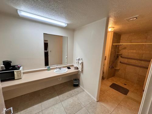 uma casa de banho com um lavatório e um chuveiro em Vista Del Rio Lodge em Chama