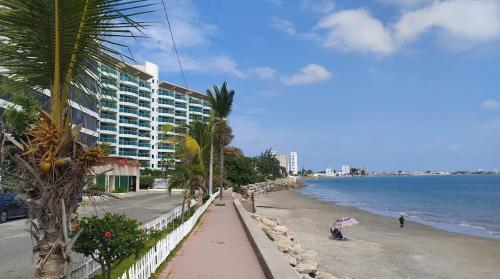 a beach with a building and a person with an umbrella at Casa Bella Salinas in Salinas