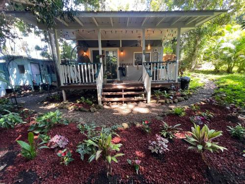 una casa con portico con panchina e fiori di Banyan Bungalow a Kealakekua