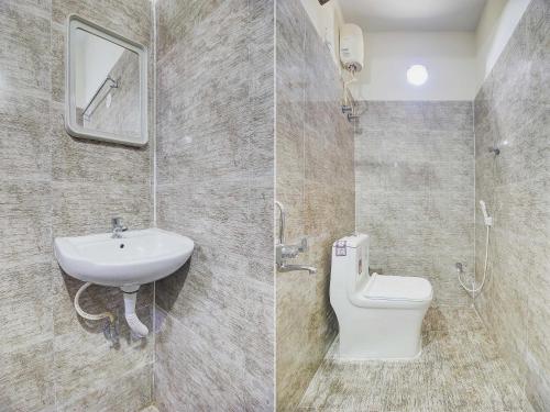 Admiral Inn Suites في نيودلهي: حمام به مرحاض أبيض ومغسلة