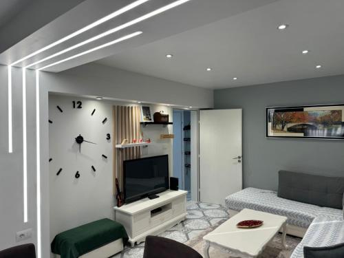 a living room with a large clock on the wall at Temali Apartment in Shkodër